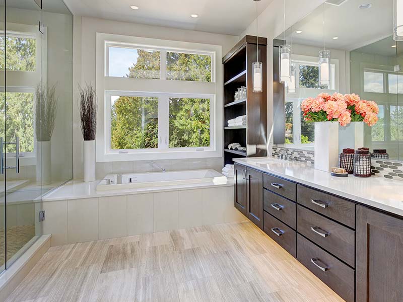 Luxurious bathroom with a large soaking tub, double vanity, and floor-to-ceiling windows remodeled by Orange Cat Flooring in Atlanta, GA.