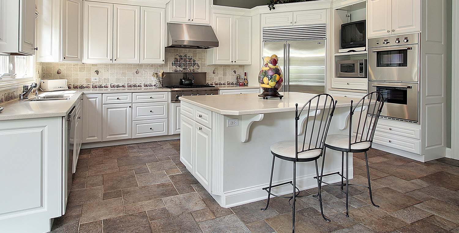 Modern kitchen with stone-look tile flooring, white cabinetry, and stainless steel appliances installed by Orange Cat Flooring in Atlanta, GA.