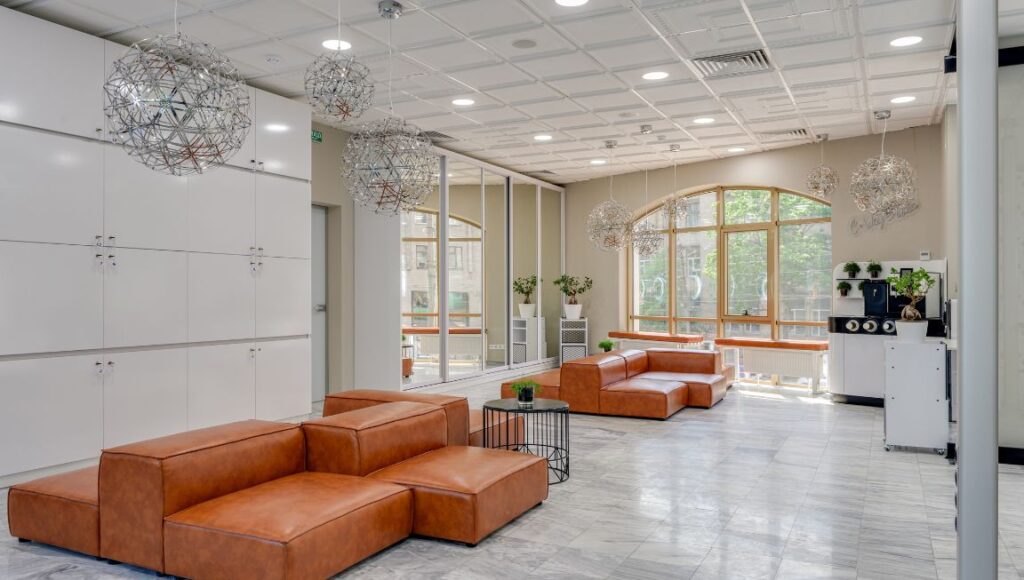 Modern office lounge area with commercial tile flooring installed by Orange Cat Flooring, featuring leather seating and stylish decor.