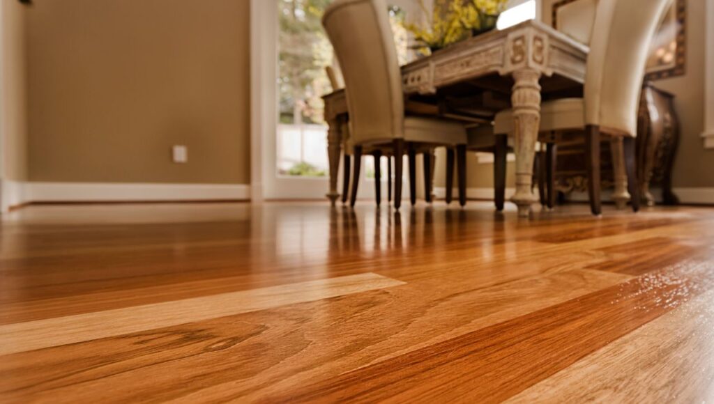 Close-up of engineered hardwood flooring installed by Orange Cat Flooring, featuring a dining room with elegant furniture in a well-lit space.